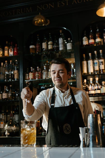 Bartender preparing colorful non-alcoholic cocktails at a bar