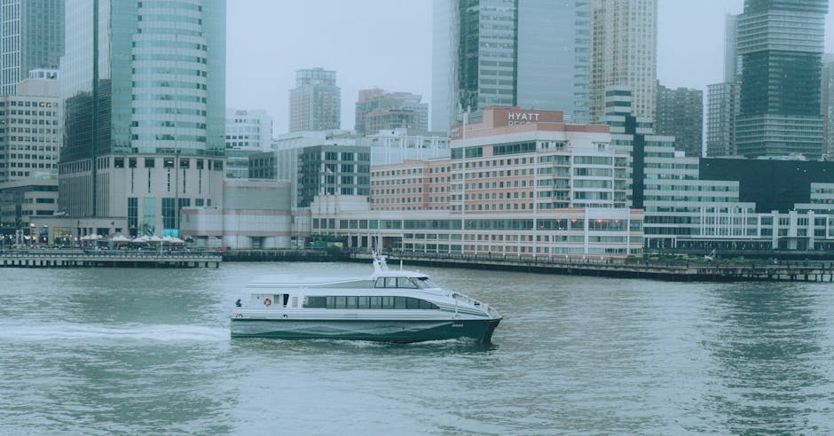 Ferry boat crossing a harbor with city skyline in background